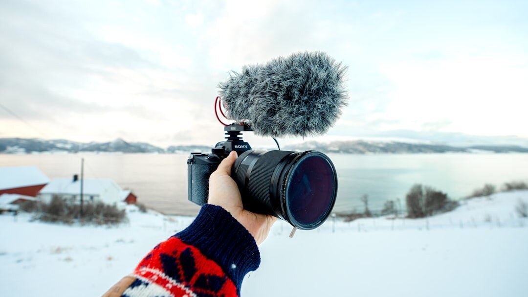 Video journalist filming outdoors with camera and microphone