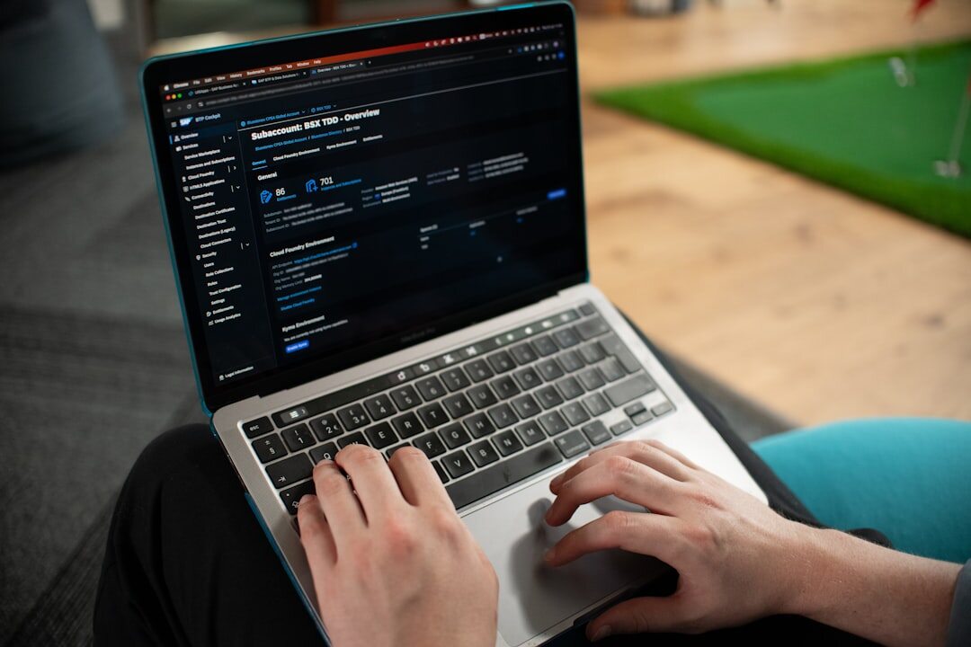 Hands typing on laptop with code and video editing software on screen